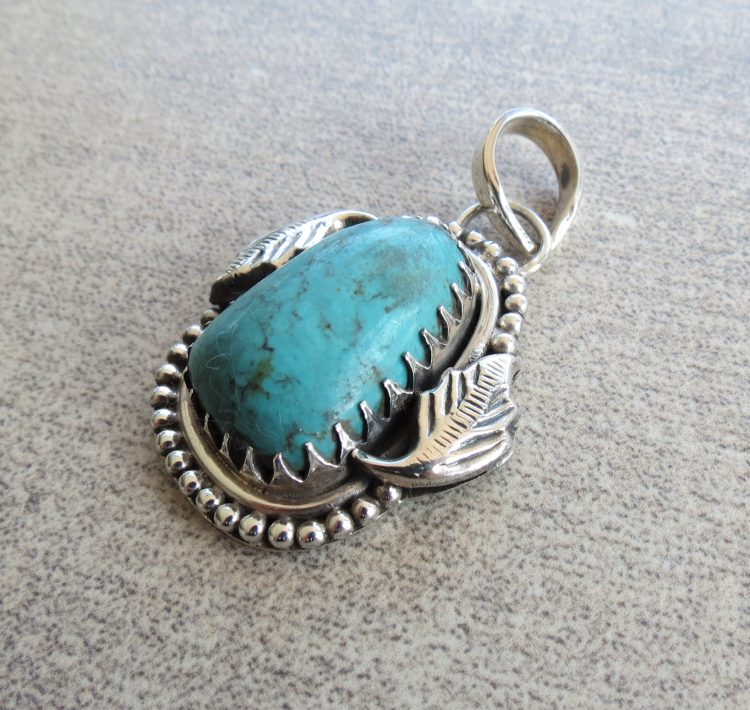 Turquoise pendant with leaf detailed sterling silver border