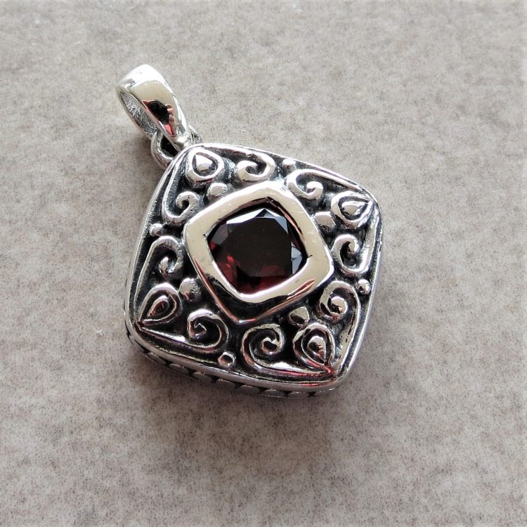 Garnet pendant with ornate sterling silver border detail