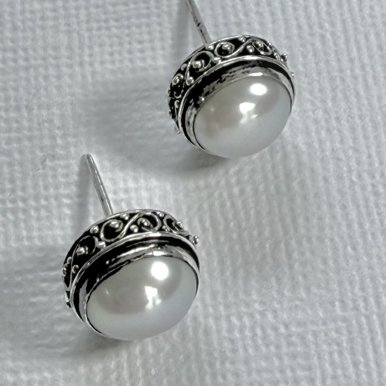 white pearl stud earrings with detailed sterling silver border