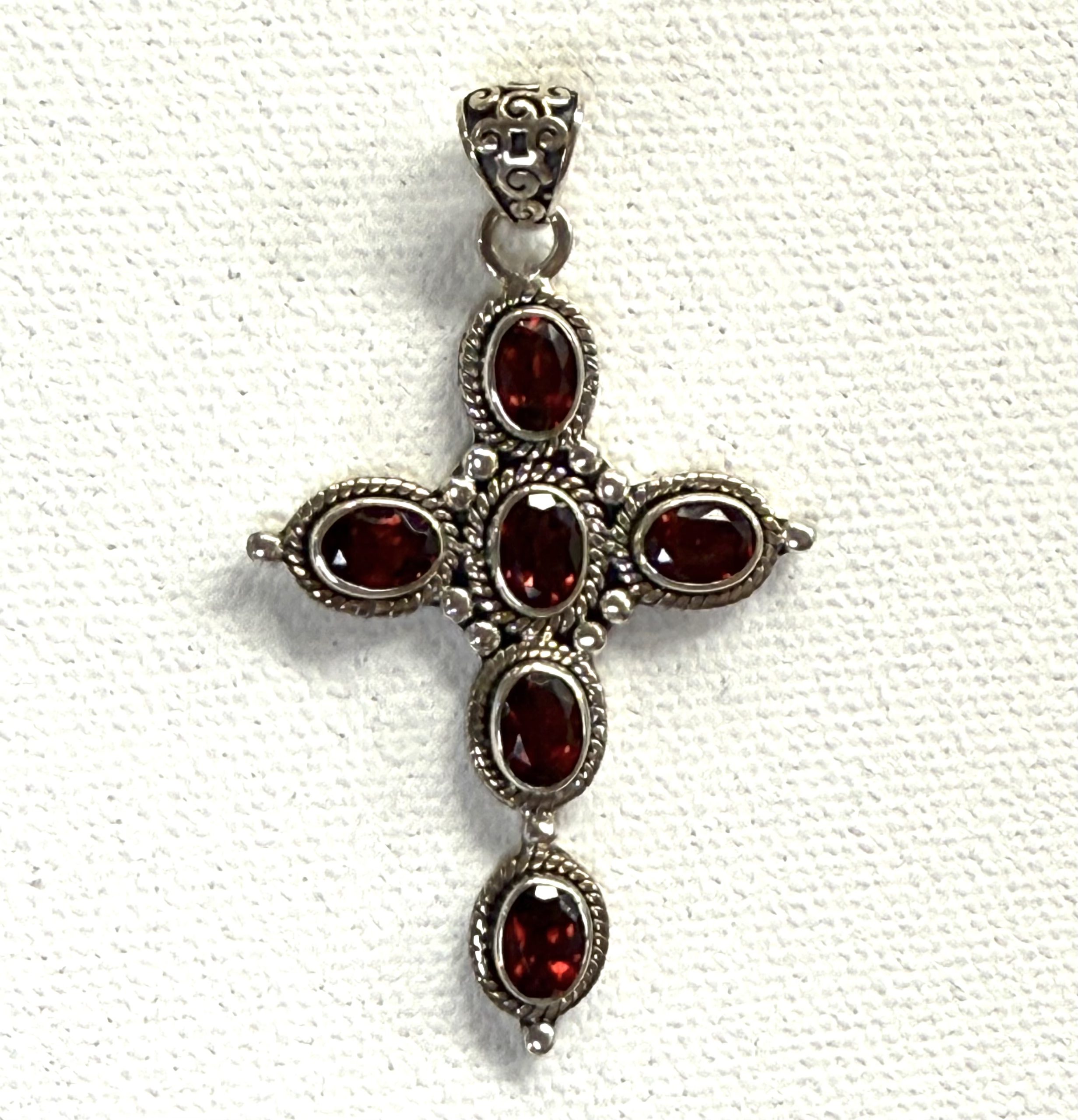 detailed sterling silver and faceted garnet cross pendant